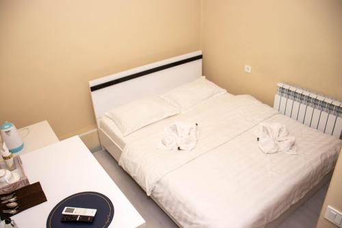 a bedroom with a bed with two towels on it at AG Hotel in Almaty