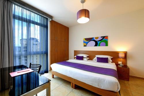 una camera da letto con un letto e un tavolo di vetro di The Smallville Xpress a Beirut