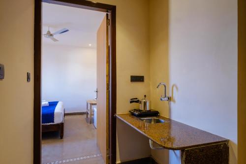 łazienka z umywalką oraz pokój z łóżkiem w obiekcie Infinia Stays - A Luxury Boutique Hotel w mieście Udaipur