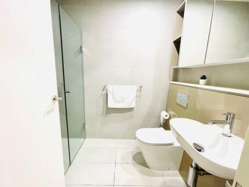ein Bad mit einem WC und einem Waschbecken in der Unterkunft Family Residence (3 Bedrooms, Pool, Gym, Parking) in Sydney