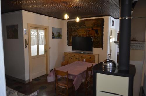 Oria的住宿－Casa Adriana，一间带桌子和电视的用餐室以及一间客房。