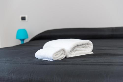 a stack of towels sitting on a bed at Travelershome 7Metri GuestHouse in Ciampino