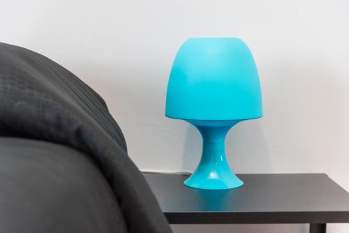 a blue lamp sitting on a table next to a bed at Travelershome 7Metri GuestHouse in Ciampino