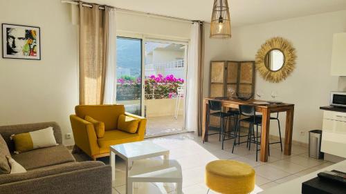 un salon avec un canapé et une table dans l'établissement Appartement Le Domaine L'ILE ROUSSE, à LʼÎle-Rousse