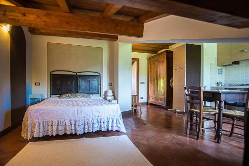 Agriturismo Il Musaccio في بارغا: غرفة نوم بسرير ومطبخ وطاولة