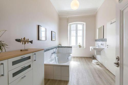 biała łazienka z wanną i umywalką w obiekcie Buedlfarm-Bauers-Haus w mieście Sahrensdorf