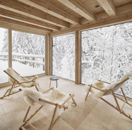 two chairs in a room with a view of snow covered trees at Alpeltalhütte in Schönau am Königssee