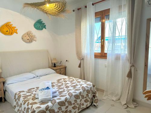 een slaapkamer met een bed met handdoeken erop bij Villa Mari Locdenia in Denia