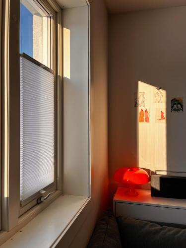 a room with a window with a red stool next to it at Hygge houses I Studio apartment in Lillestrøm I Solo or Couple in Lillestrøm