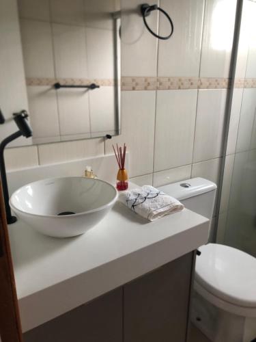 a bathroom with a bowl sink and a toilet at Casa para temporada in Florianópolis