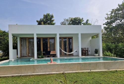 a woman laying in the swimming pool of a house at Giri Villa in Tangalle
