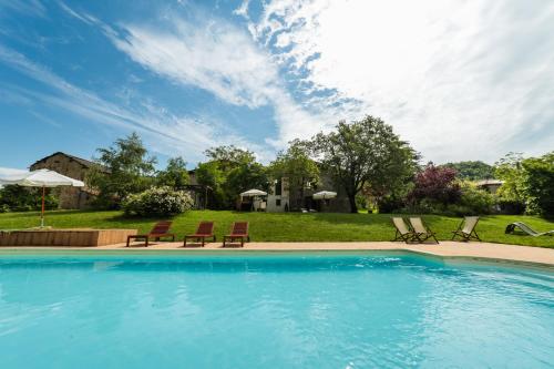 a swimming pool with lounge chairs and a yard at Borgo Pianello Country Resort in Lizzano in Belvedere