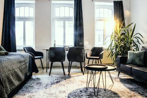 a living room with a table and chairs at NUWILU ONE - Apartment mit Balkon im Herzen Erfurts - Magenta TV- Netflix - Disney in Erfurt