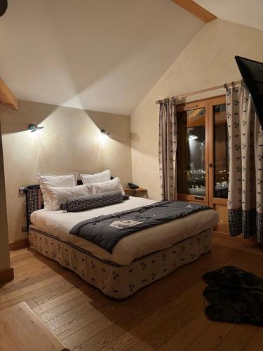 a bedroom with a large bed and a window at Hôtel le Jalouvre in Mont-Saxonnex