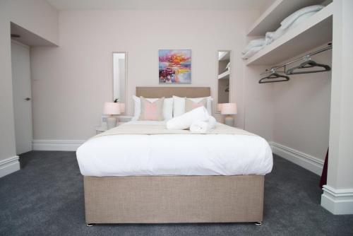 1 dormitorio con 1 cama grande con sábanas blancas en Archer Road Penarth Free parking en Cardiff