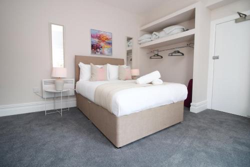 a white bedroom with a large bed and a table at Archer Road Penarth Free parking in Cardiff