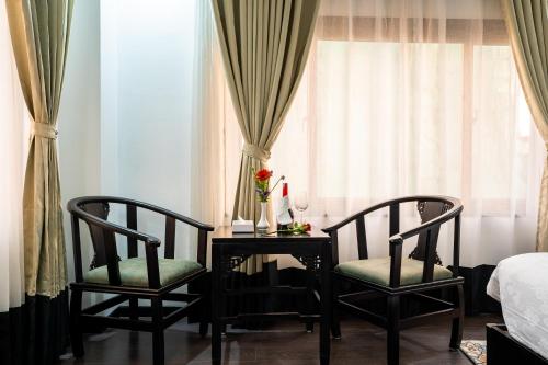 um quarto com duas cadeiras, uma mesa e uma cama em Hotel Lo Mustang em Kathmandu