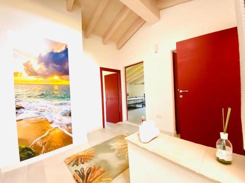 a bathroom with a red door and a painting of the ocean at The 4 Senses Experience in Suvereto