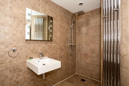 y baño con lavabo y espejo. en CoffiCo Hotel, en Cardiff