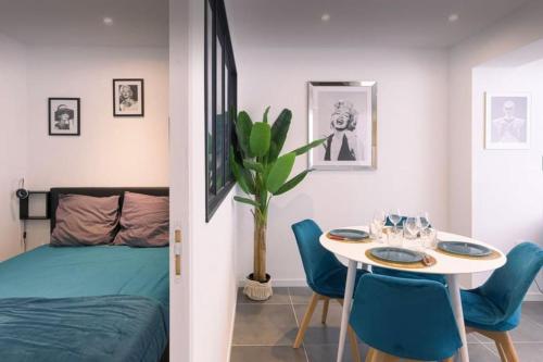 une chambre avec un lit, une table et des chaises dans l'établissement appartement Carré d’or 2 pas de la croisette, à Cannes