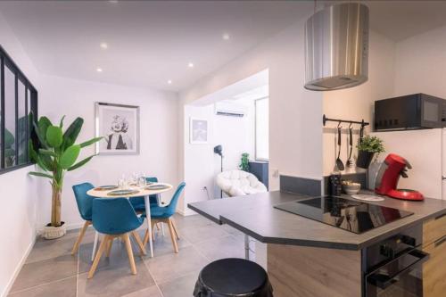 une cuisine et une salle à manger avec une table et des chaises dans l'établissement appartement Carré d’or 2 pas de la croisette, à Cannes