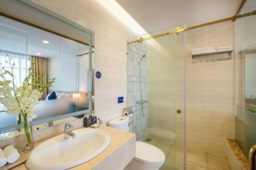 uma casa de banho com um lavatório, um WC e um chuveiro em Sandals Star Hotel em Ðưc Trọng