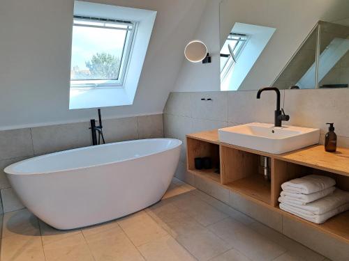 uma casa de banho com uma grande banheira branca e um lavatório. em Eck am Meer 6 em Eckernförde