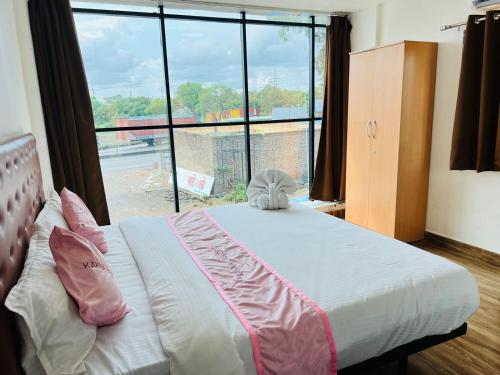 1 dormitorio con 1 cama y ventana grande en Hotel Karna Residency , Ranjangaon, en Ranjangaon