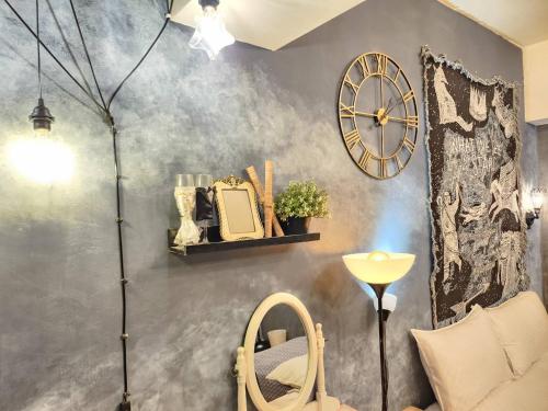 a room with a wall with a clock and a chair at 一中喵喵 有統編收據 禁菸 非自助 in Taichung
