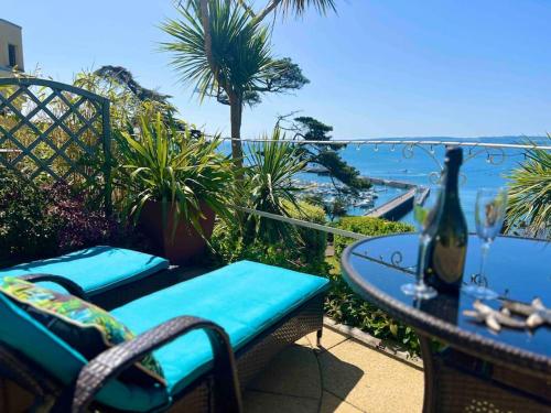 a table and chairs with a view of the ocean at Luxury Riviera View Waterside Apartment in Torquay