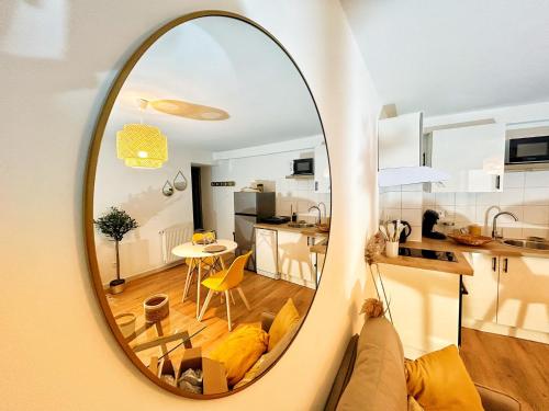 un miroir reflétant un salon et une cuisine dans l'établissement Cosy Ocre, à Arles