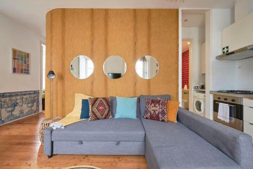 ein Sofa im Wohnzimmer mit runden Spiegeln in der Unterkunft Inglesinhos Convento 1 - Charming Apartment in Lissabon