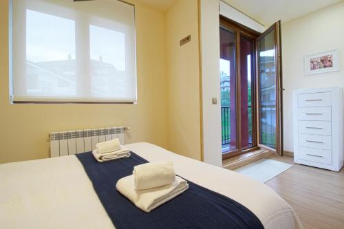 a bedroom with a bed with two towels on it at La Casa del Muelle in Suances