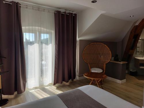 a bedroom with a bed and a window and a chair at Logis Auberge Des Voyageurs in Vandières