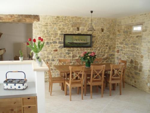 a kitchen and dining room with a table and chairs at Les Chaufourniers / L'Ecurie in Crouay