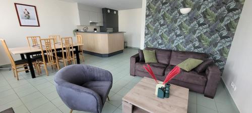 un salon avec un canapé et une table dans l'établissement T3 “Hoedic“- 50 m de la plage de Fort Bloqué/Ploemeur, à Ploemeur