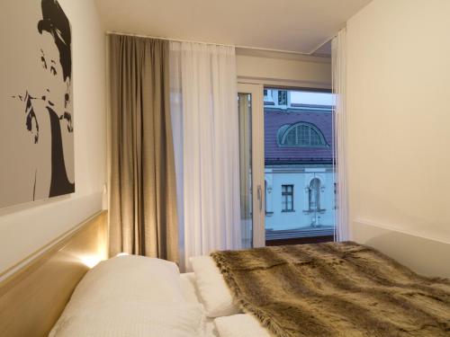 sypialnia z łóżkiem i dużym oknem w obiekcie Balcony Dream Mariahilf Top 29 w Wiedniu