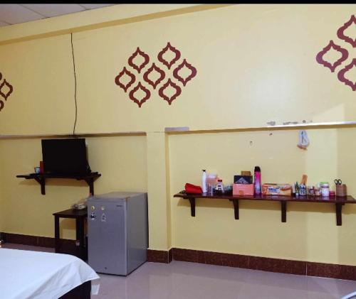 um quarto com uma parede com uma prateleira e um frigorífico em The Hideout em Kampot