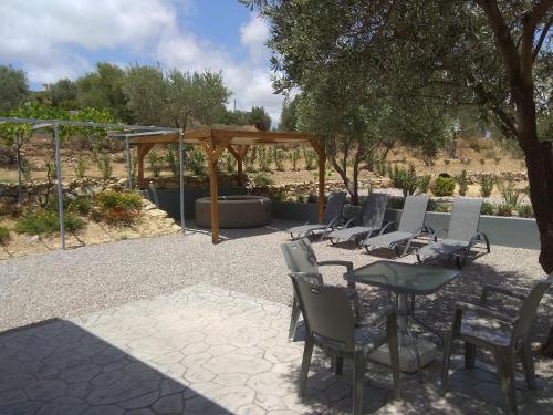 grupa krzeseł i stół na patio w obiekcie Evgenias Olive House w mieście Kalathos