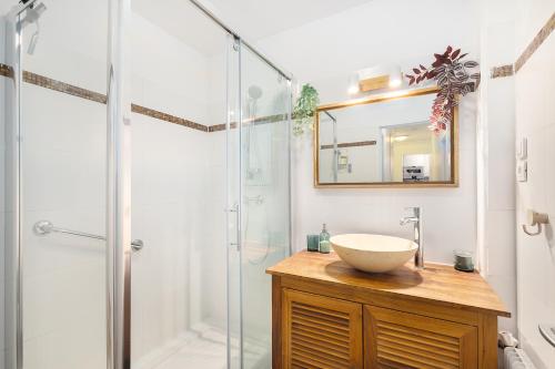 une salle de bain avec un lavabo et une douche en verre dans l'établissement Cosy'n Paris - Parking secure - Metro 14 - Wifi - Terrace - Premium bedding, à Gentilly