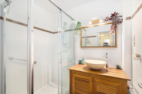 a bathroom with a sink and a glass shower at T3 - PARIS 10' Confort & Modern - Terrasse - Parking - WIFI in Gentilly