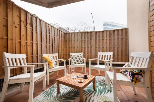 eine Terrasse mit Stühlen, Tischen und einem Zaun in der Unterkunft T3 - PARIS 10' Confort & Modern - Terrasse - Parking - WIFI in Gentilly