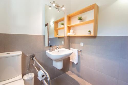 a bathroom with a sink and a toilet and a mirror at Villa Macarella by Sonne Villas in Cala Galdana