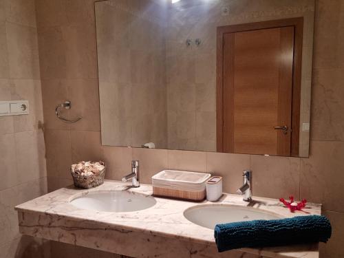a bathroom with two sinks and a large mirror at APARTAMENTO CONSTITUCIÓN in Benicarló