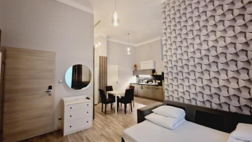 a bedroom with two beds and a table and a kitchen at Elegance Studios in Vienna