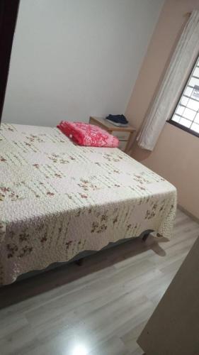 um quarto com uma cama com uma almofada cor-de-rosa em AMPLA CASA CONFORTAVEL NO GUARUJA CASCAVEL em Cascavel