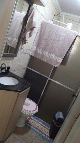 ein kleines Bad mit einem Waschbecken und einem WC in der Unterkunft AMPLA CASA CONFORTAVEL NO GUARUJA CASCAVEL in Cascavel