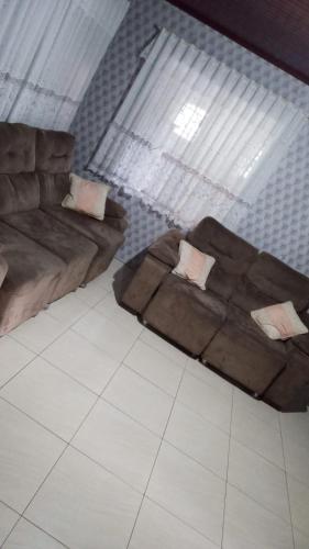 a living room with two couches and a large window at AMPLA CASA CONFORTAVEL NO GUARUJA CASCAVEL in Cascavel