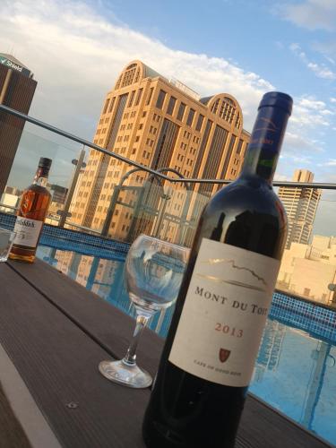 a bottle of wine and a wine glass on a balcony at Cosy Apartment in Johannesburg in Johannesburg