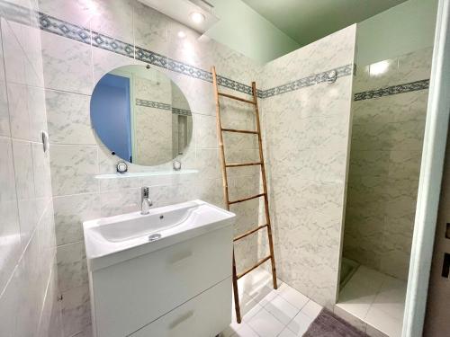 La salle de bains est pourvue d'un lavabo, d'un miroir et d'une échelle. dans l'établissement Studio l'orée du bois AJACCIO, à Ajaccio